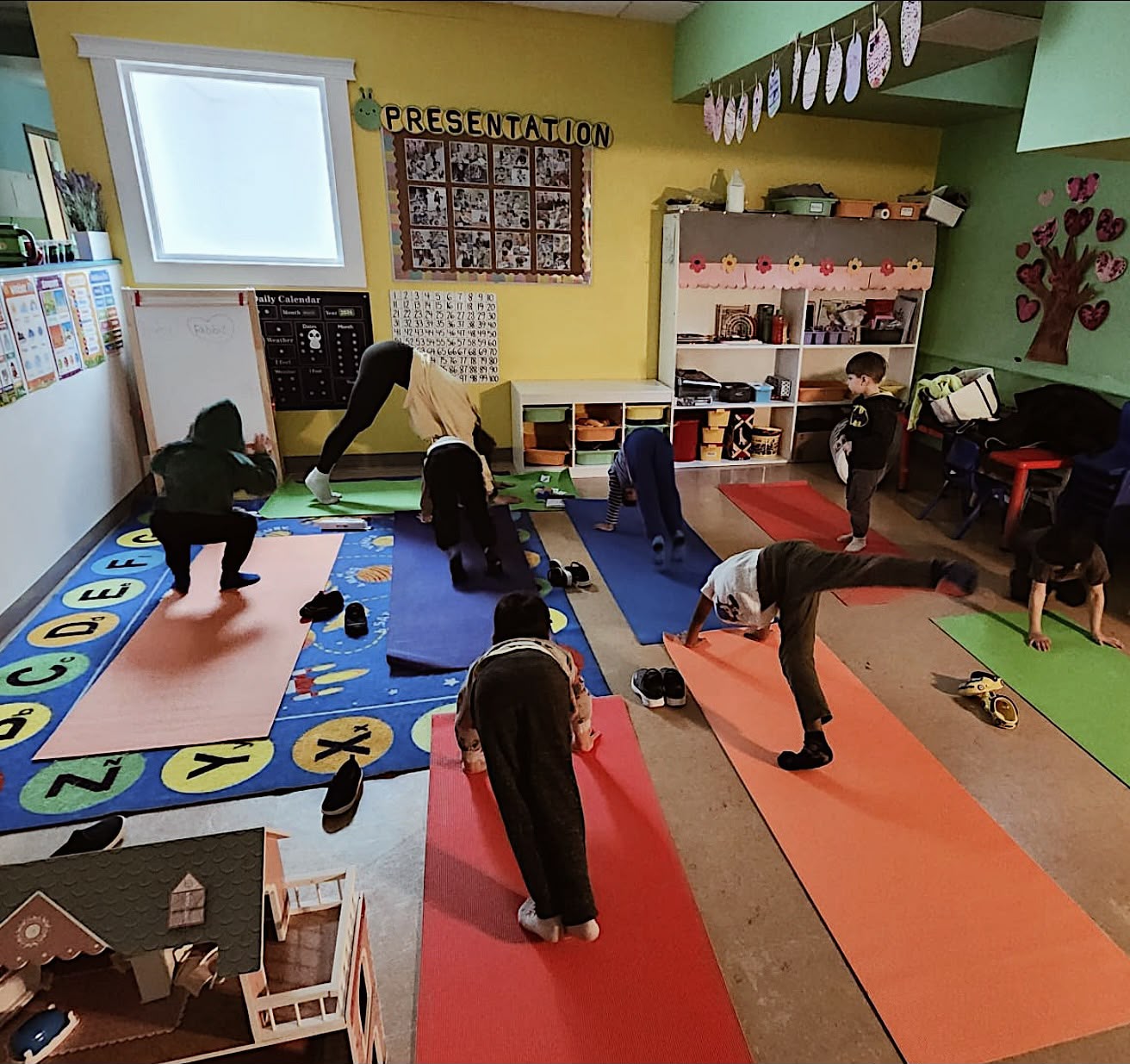 Children practicing yoga poses together at a daycare